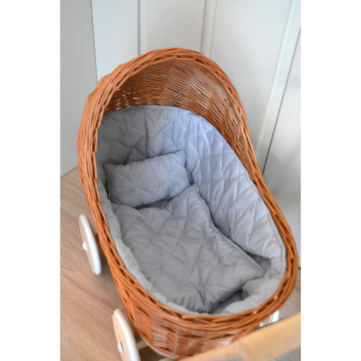 Cărucioare pentru copii din ratan maro cu roți de cauciuc și păturică.