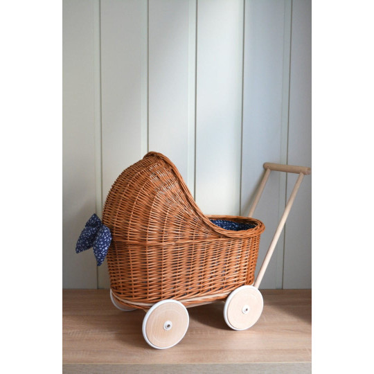 Cărucioare din rattan pentru copii, de culoare maro, cu o păturică albastră.