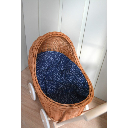 Cărucioare din rattan pentru copii, de culoare maro, cu o păturică albastră.