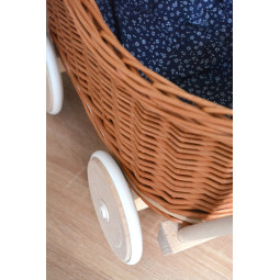 Cărucioare din rattan pentru copii, de culoare maro, cu o păturică albastră.