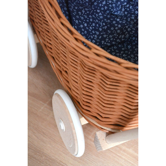 Cărucioare din rattan pentru copii, de culoare maro, cu o păturică albastră.