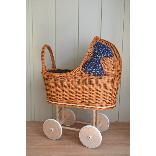 Cărucior din rattan pentru copii, cu fundiță albastră și roți din cauciuc.