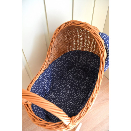 Cărucior din rattan pentru copii, cu fundiță albastră și roți din cauciuc.