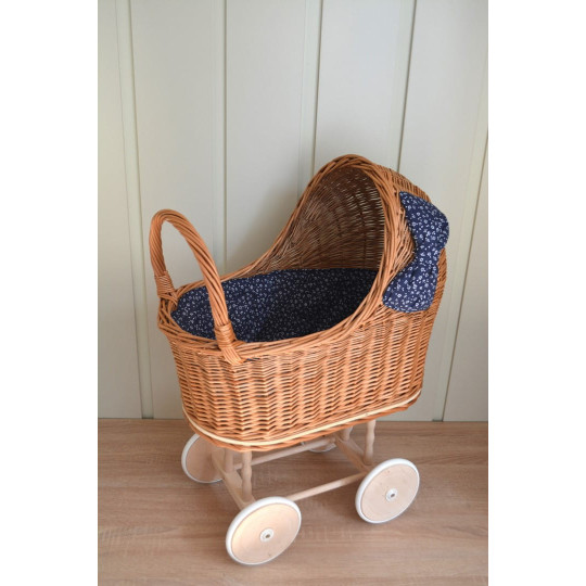 Cărucior din rattan pentru copii, cu fundiță albastră și roți din cauciuc.