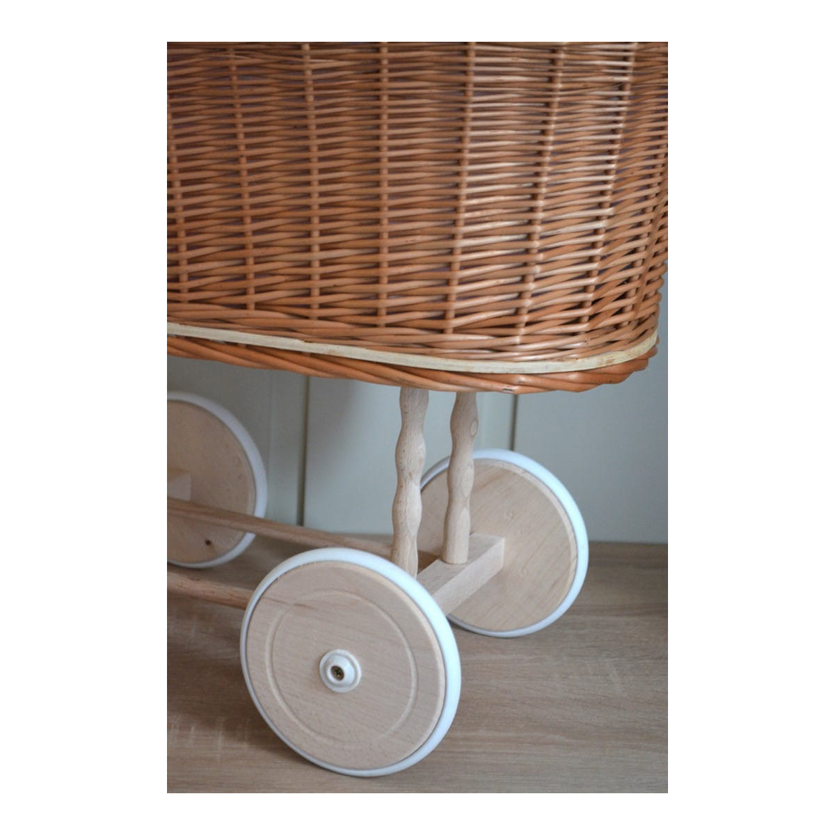 Cărucior pentru păpuși de culoare marron cu păturică roz și fundiță