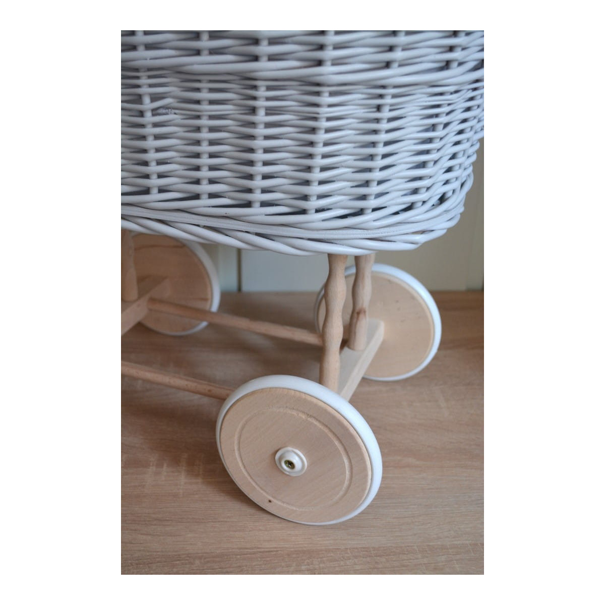 Cărucior gri pentru păpuși cu o pătură albă și o fundiță