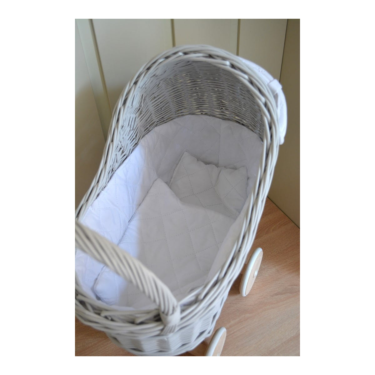 Cărucior gri pentru păpuși cu o pătură albă și o fundiță