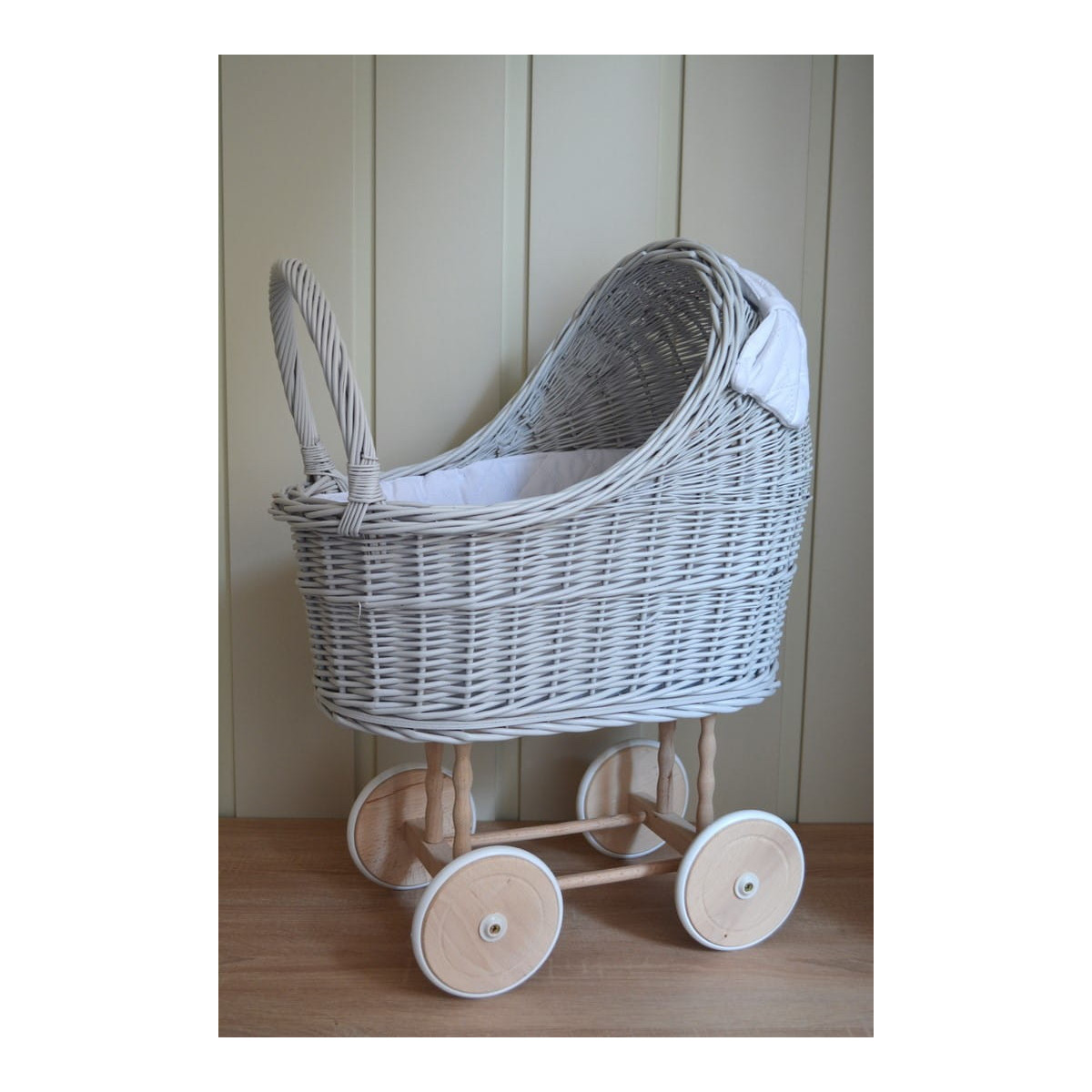 Cărucior gri pentru păpuși cu o pătură albă și o fundiță