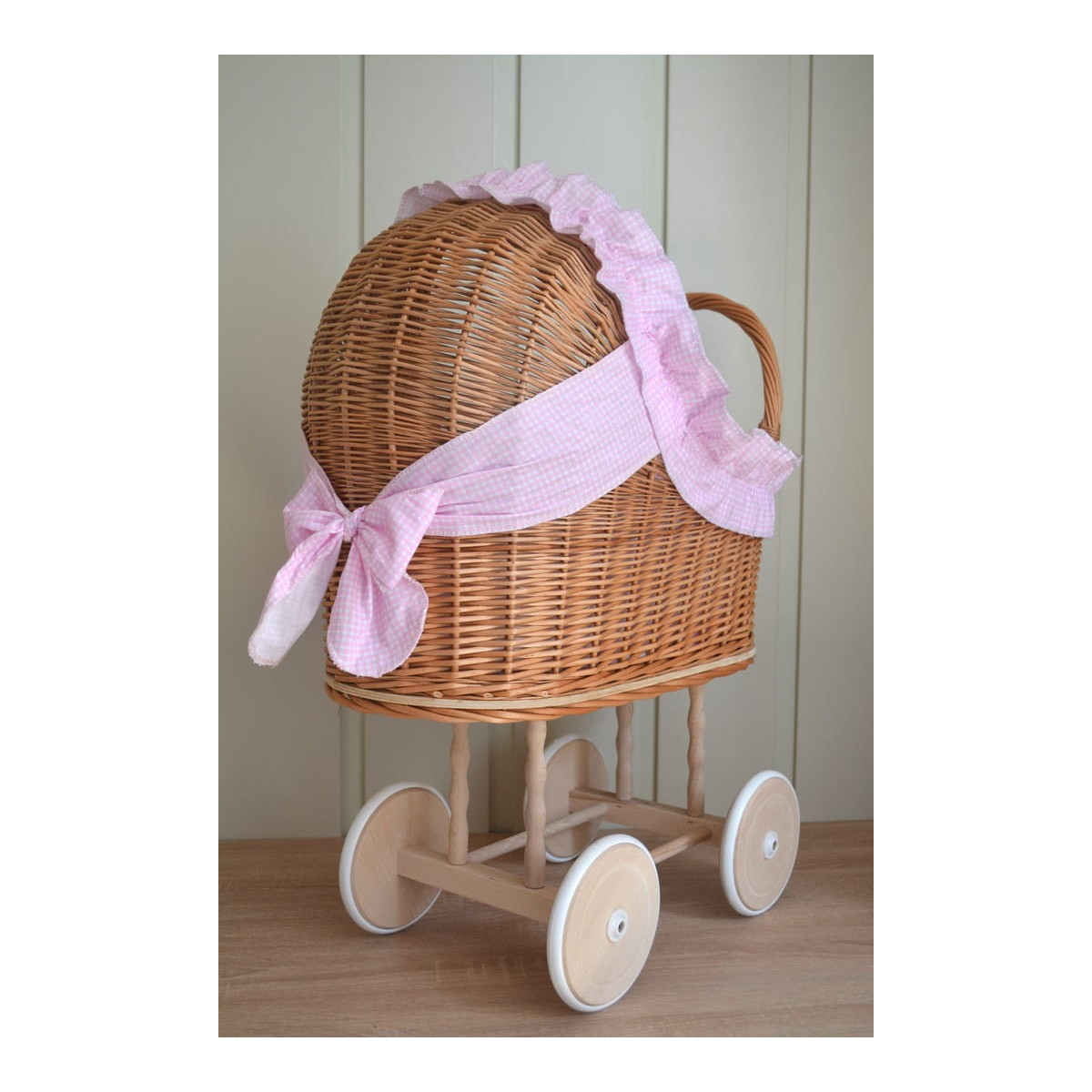 Carucior din material natural cu volan roz.