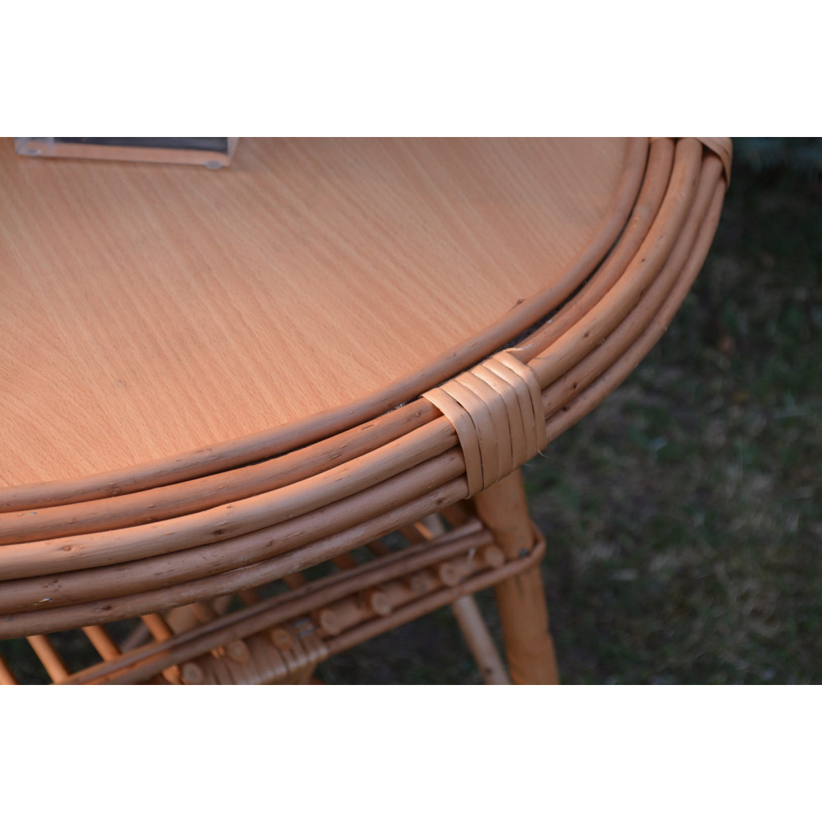 Masa rotundă mare din ratan natural cu blat deschis.