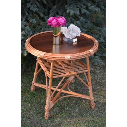 Masă rotundă mare din ratan natural cu blat închis.