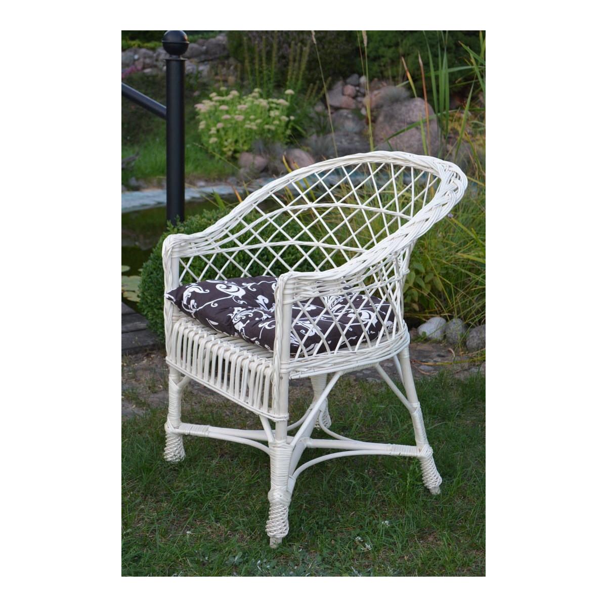 Scaun de grădină de culoare albă, cu pernă maronie cu flori crem.