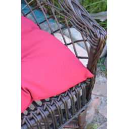 Scaun din ratan de culoare maro închis cu pernă roșie