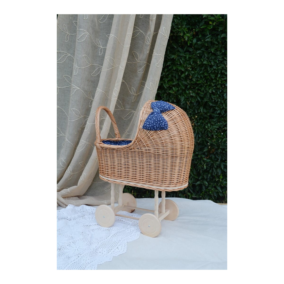 Cărucioare de copii de calitate din răchită, cu fundiță albastră și păturică.