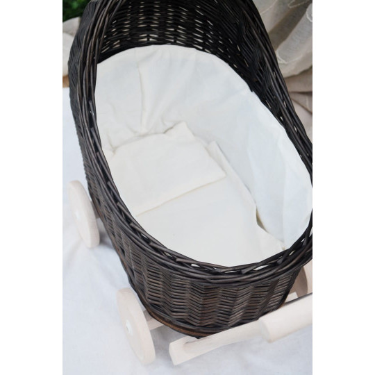 Cărucior pentru copii din rattan original, de culoare brownă, cu o fundiță albă.