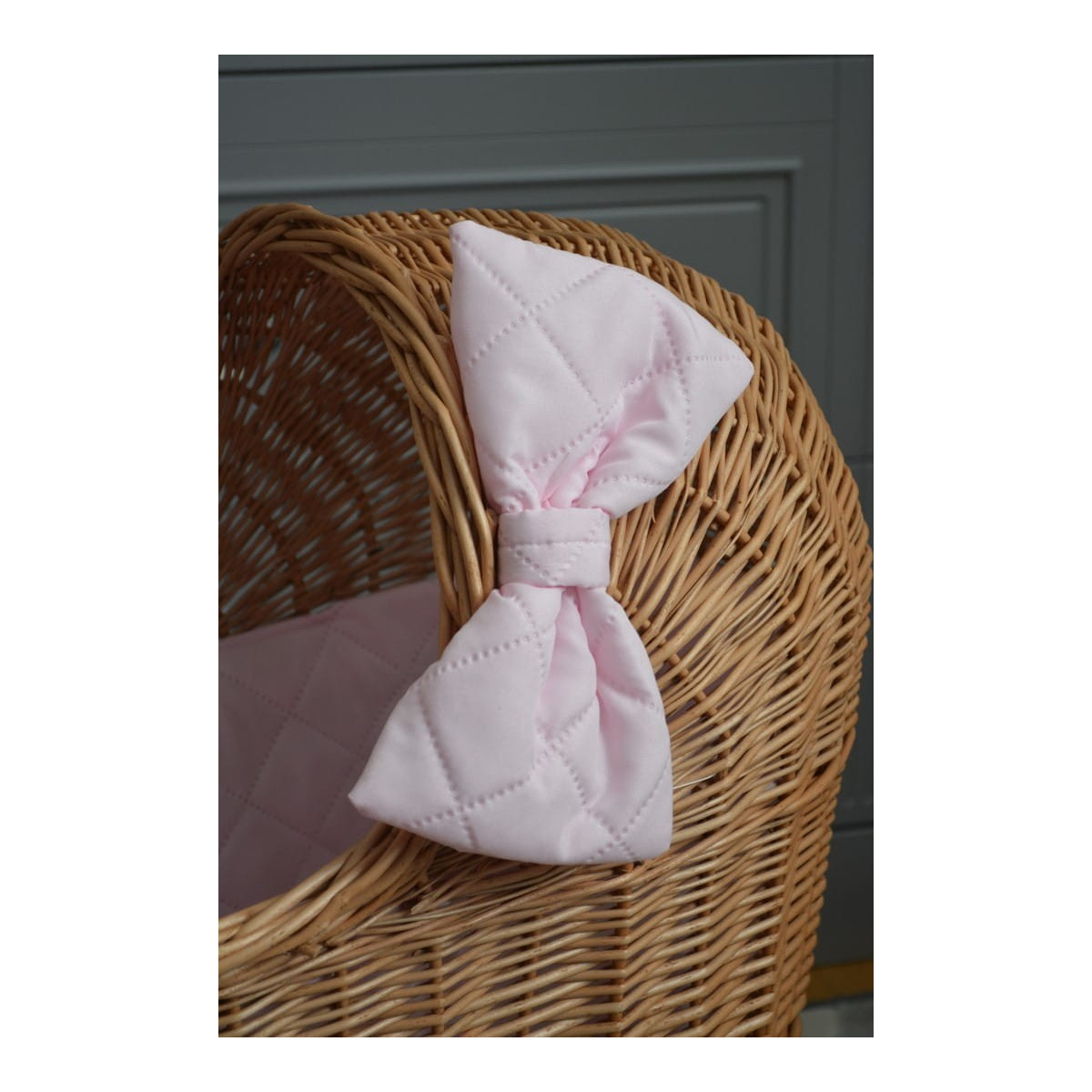 Cărucior pentru păpuși țesut manual, cu umplutură roz și fundiță.