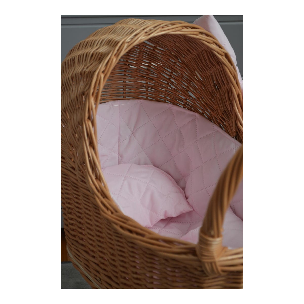 Cărucior pentru păpuși țesut manual, cu umplutură roz și fundiță.